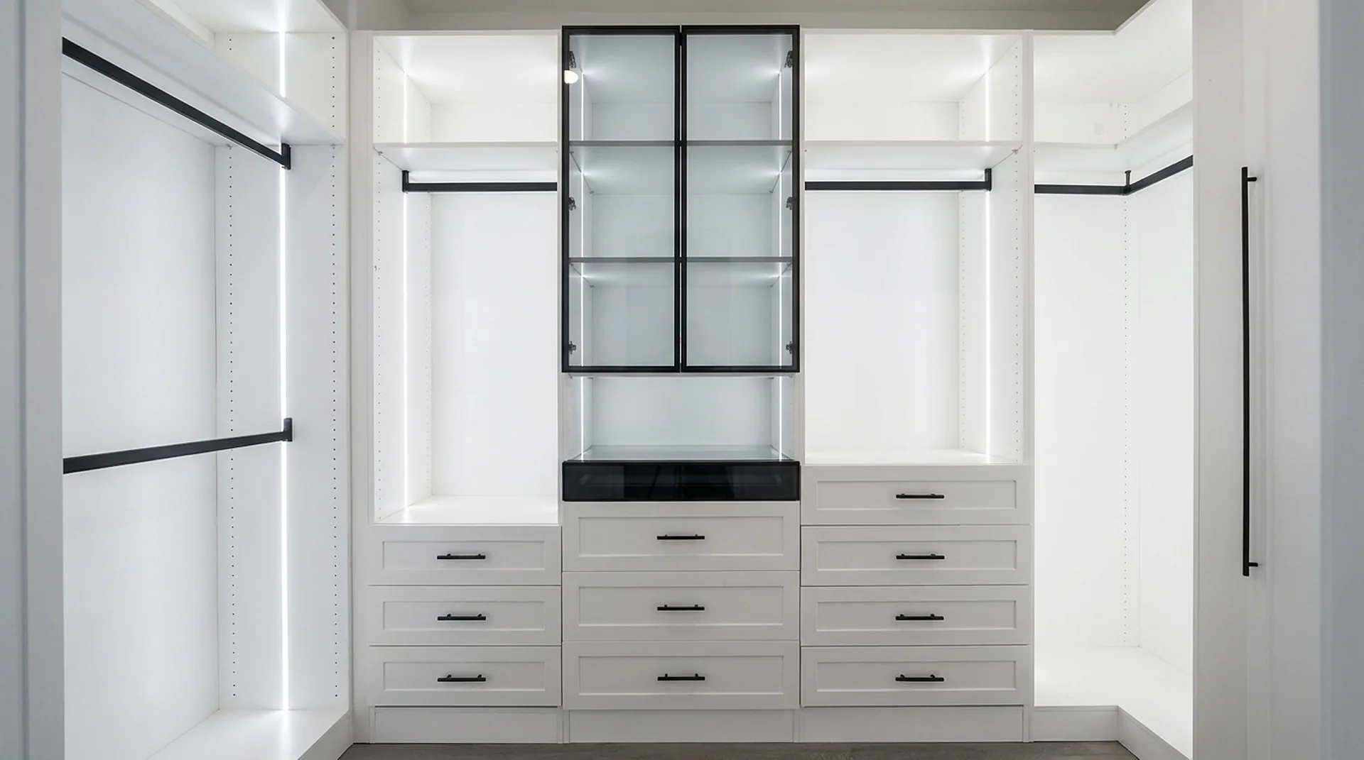 Closet wall with drawer base cabinets, LED rails and glass center tower