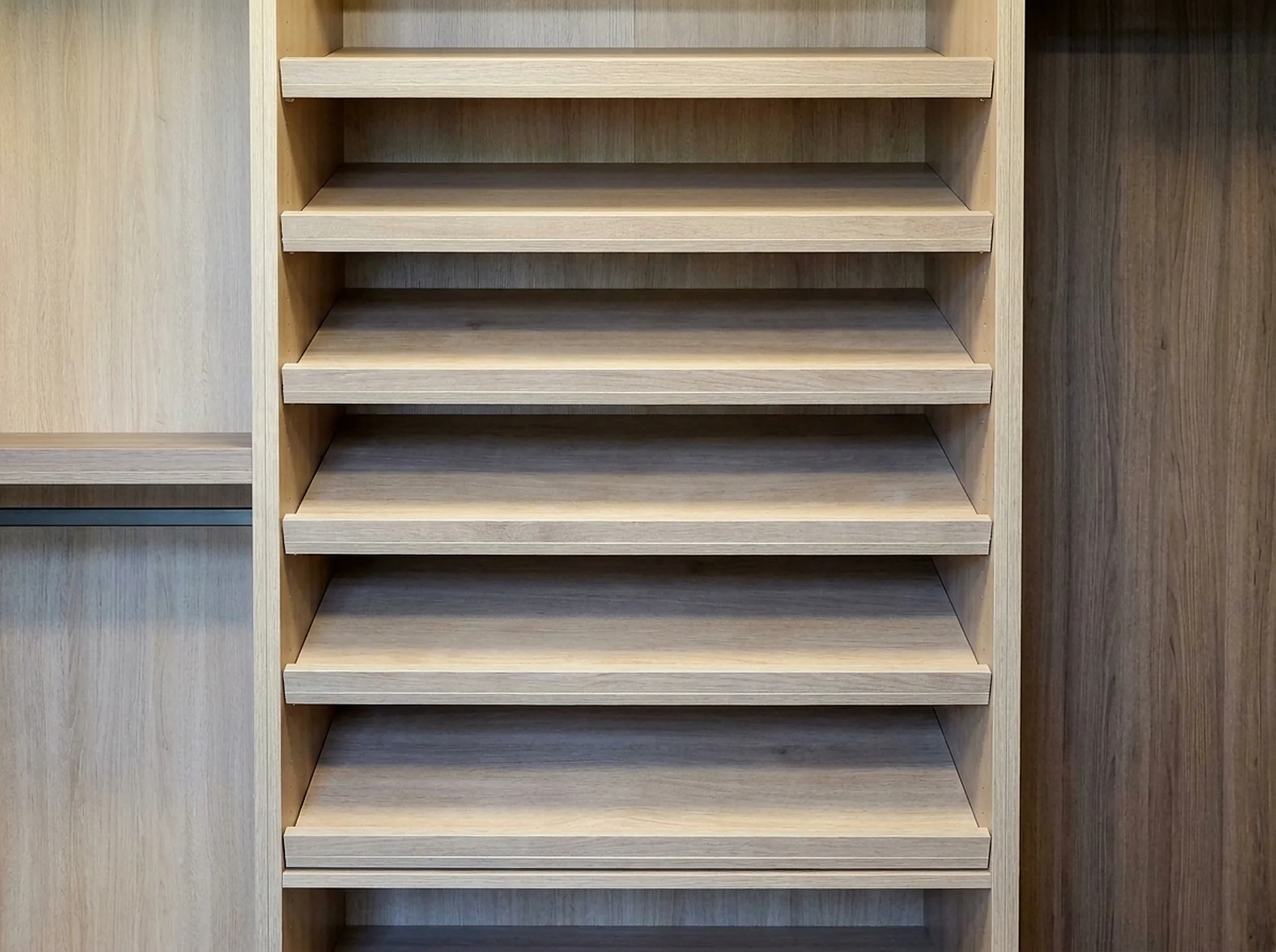 Angled shoe rack shelf installed inside a custom closet tower